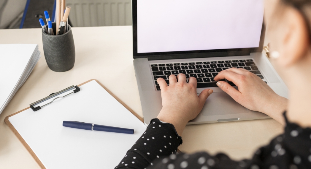 high-angle-woman-working-on-an-empty-display-laptop